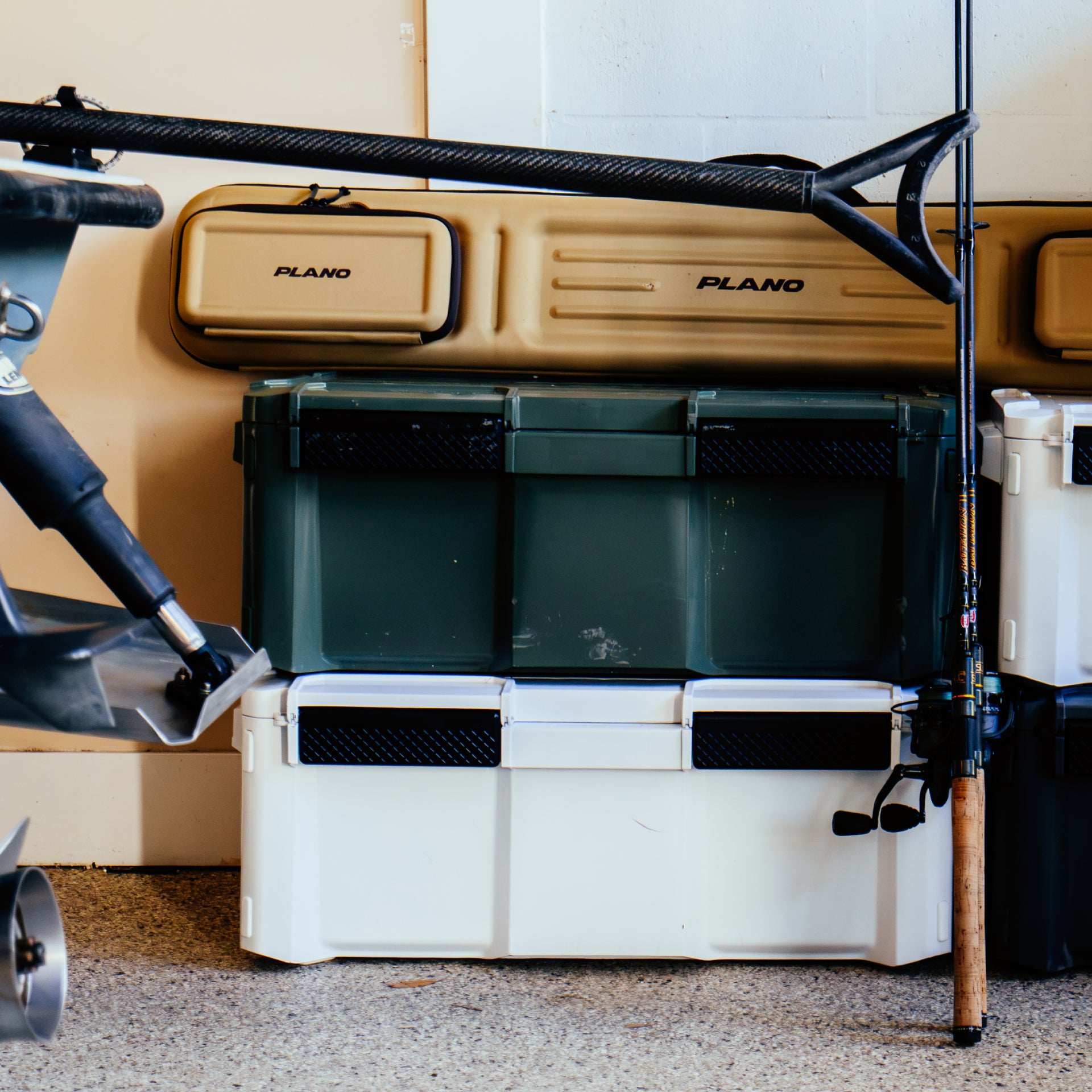 Fishing tackle box with Plano branding on a vehicle, surrounded by fishing equipment.