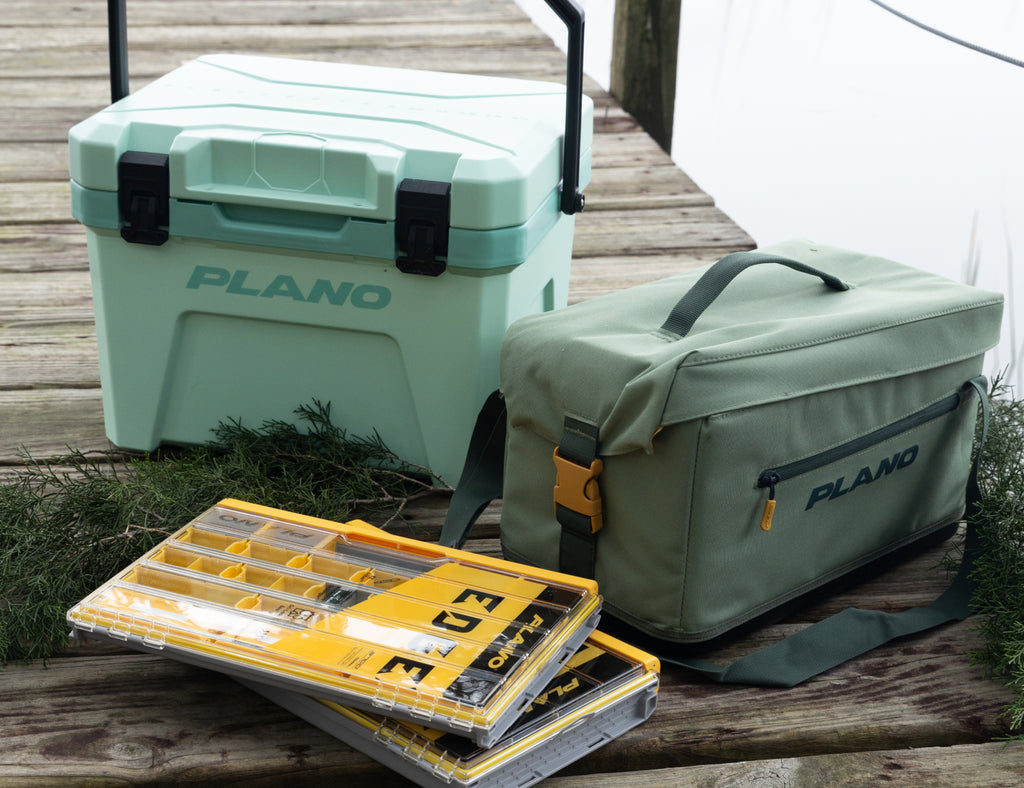 Plano cooler and bag on a wooden deck with tackle boxes.
